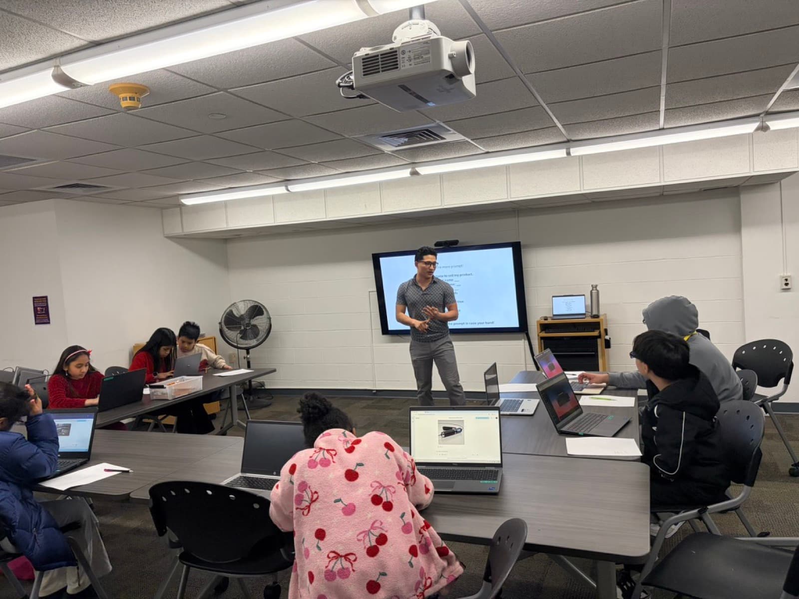 Brayan teaching a full classroom to build with AI